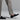 A person wears light gray dress pants with Anthony Veers Belmont Penny Loafer in Velvet Noir Black Suede, seen from the waist down against a neutral background.